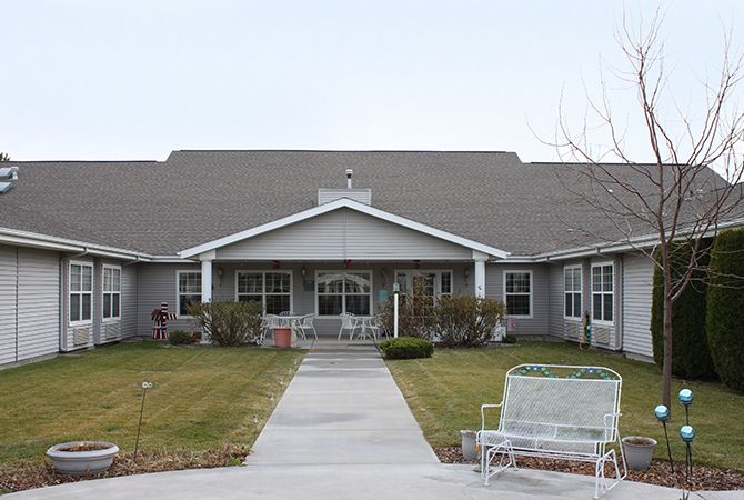 A view of a residential building with a garden and pathway leading to the entrance.