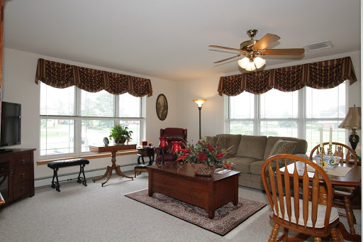 A cozy and well-lit living room featuring comfortable furniture and decorative elements.
