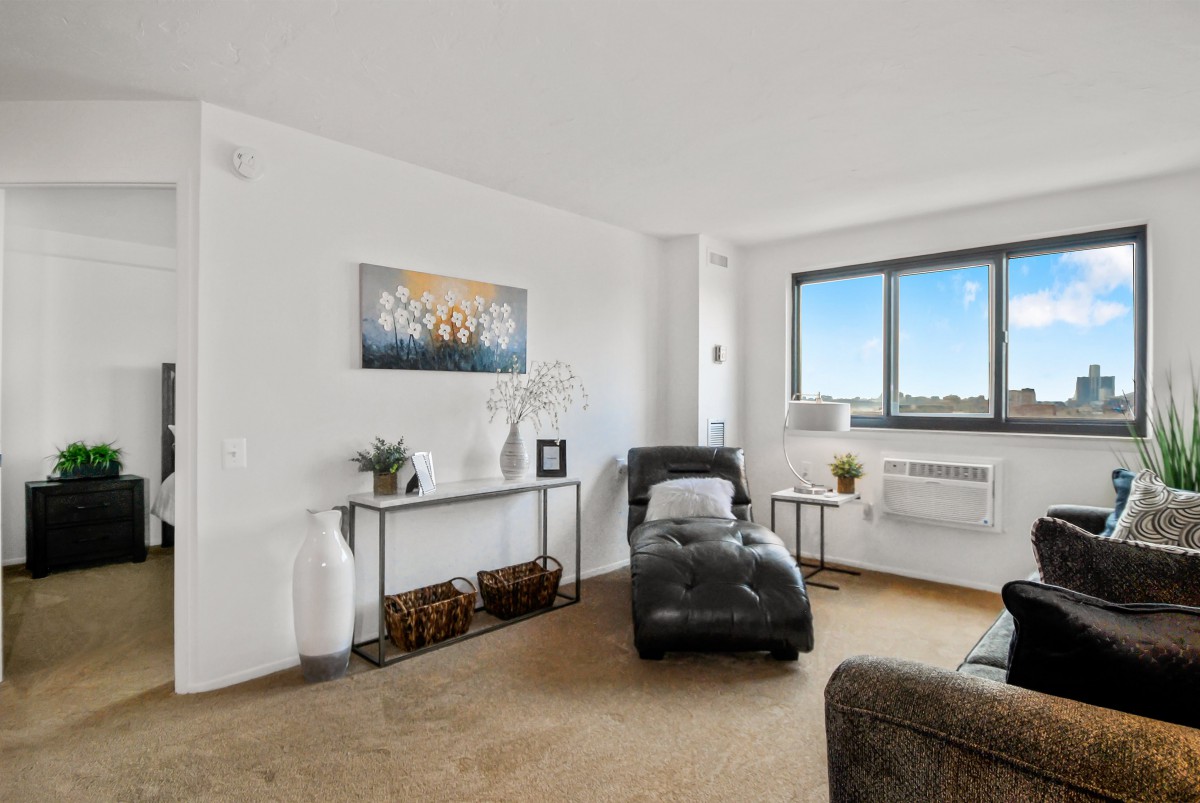 A modern living room with a chaise lounge and minimalistic decor.