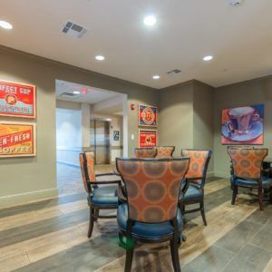 A modern and cozy dining area featuring colorful chairs, tables, and wall art.