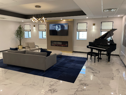 A stylish modern living room featuring a grand piano, comfortable seating, and elegant decor.