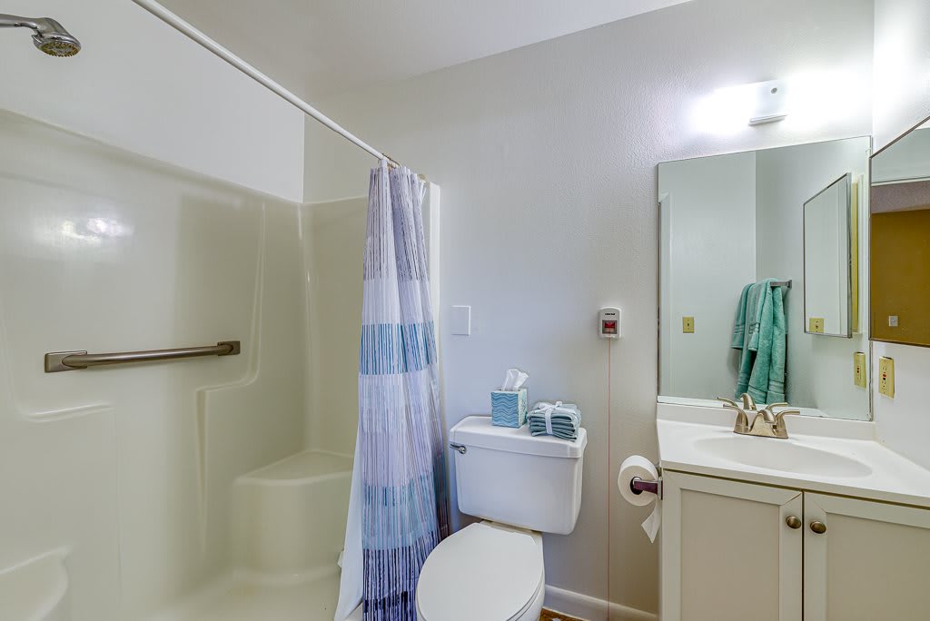 A clean and simple bathroom with a shower, toilet, and sink.