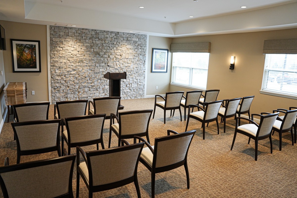 An empty conference room with chairs arranged facing a podium.
