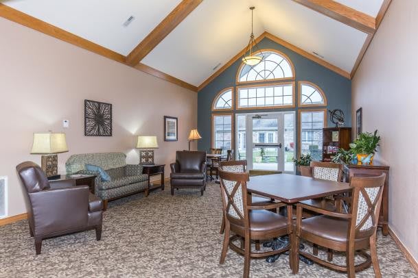 A cozy living area with a vaulted ceiling, ample seating, and large windows letting in natural light.