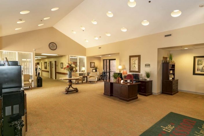 A well-lit lobby area with a reception desk and seating.