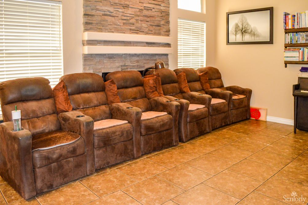 A cozy home theater setup with a row of plush recliner chairs.