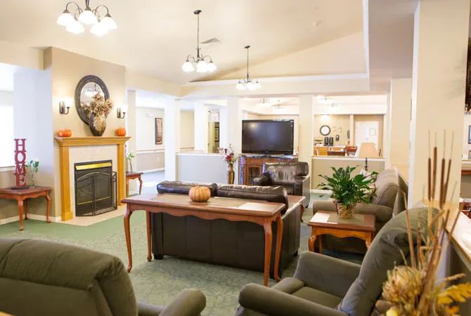 A cozy and well-furnished living room with a fireplace, television, and comfortable seating.