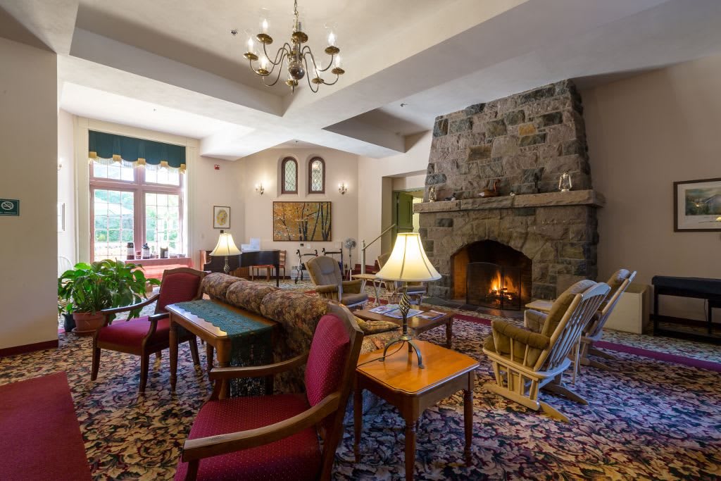 A cozy living room with a large stone fireplace and comfortable seating.