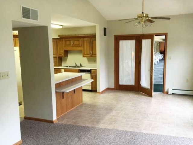 Open kitchen and living area with wood cabinets and French doors leading outside.
