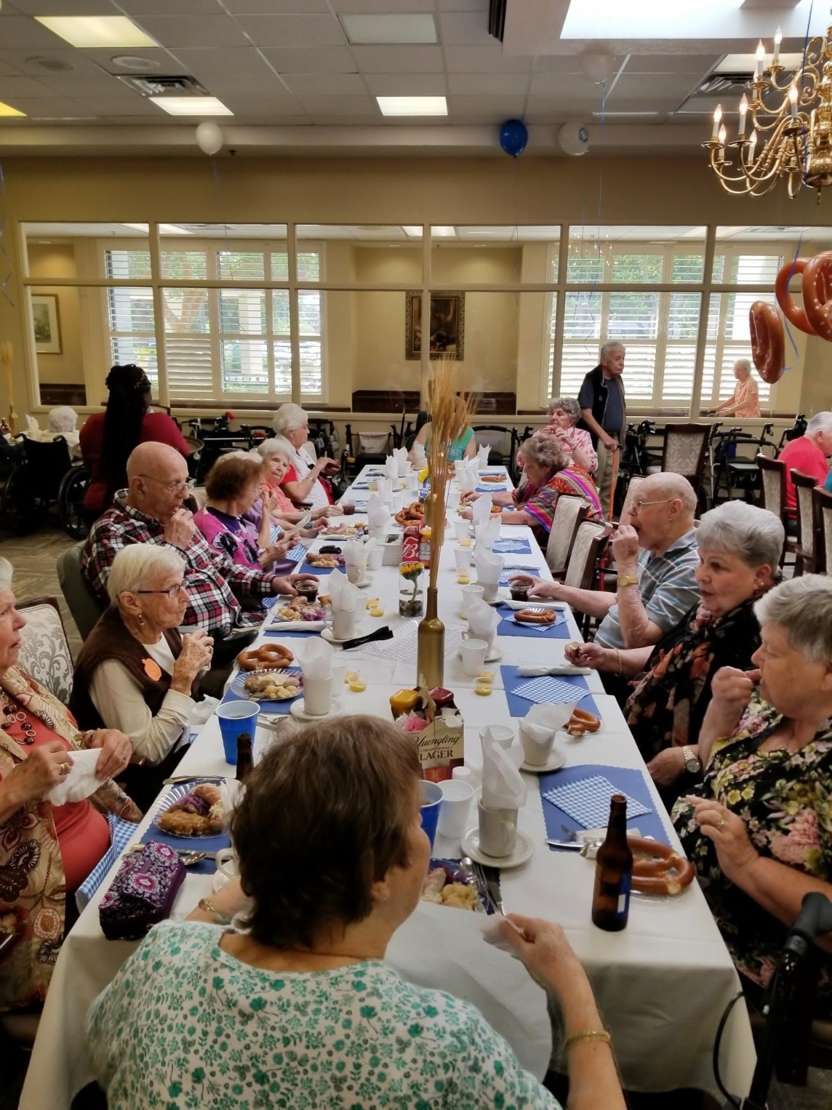 A group of elderly individuals enjoying a meal together at a celebratory gathering indoors.