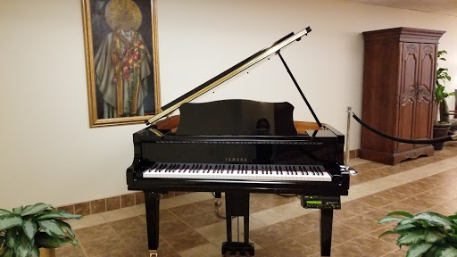 A sleek black grand piano positioned elegantly in a well-decorated indoor space.