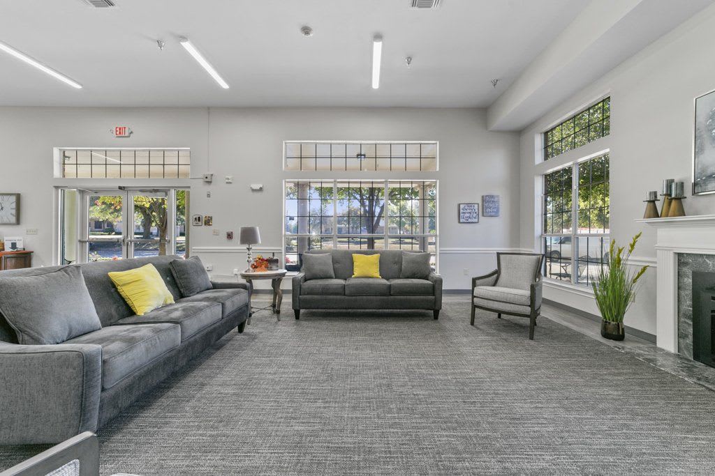 A modern lounge area with sofas and large windows.