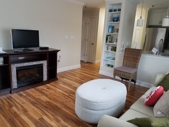 Cozy living room with a fireplace and wooden flooring.