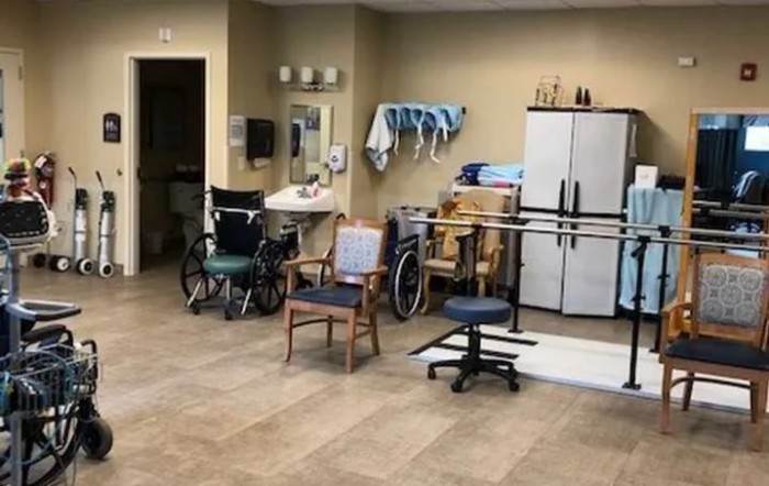 A physical therapy room equipped with wheelchairs and various rehabilitation tools.
