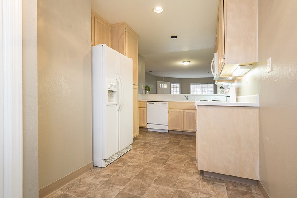 A spacious kitchen with light wood cabinetry and modern appliances.