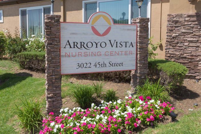 The entrance sign for Arroyo Vista, surrounded by colorful flowers.