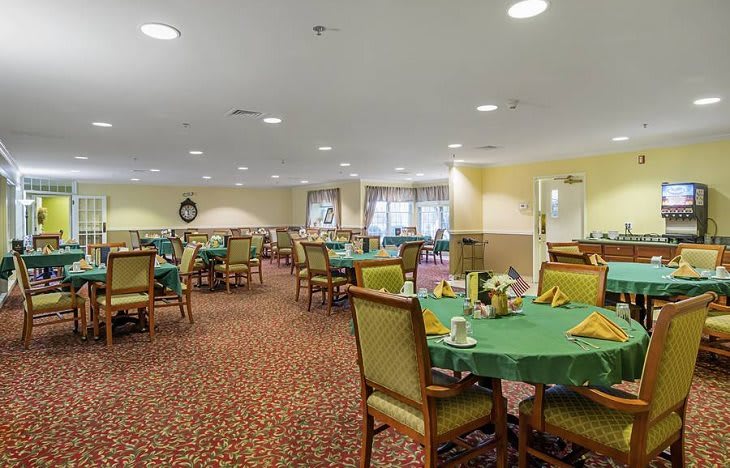 An indoor dining room with tables and chairs set for a meal.