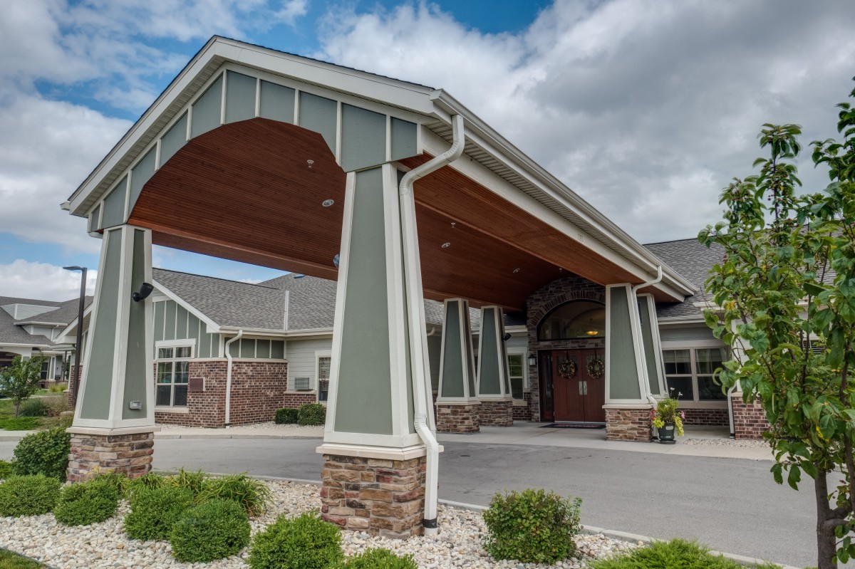 A modern building entrance with a covered walkway and landscaped surroundings.