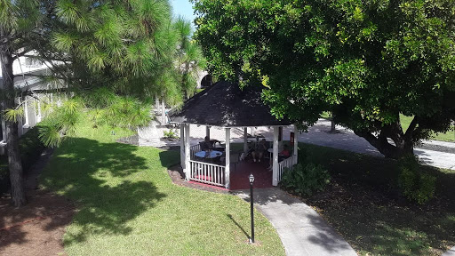 A peaceful gazebo surrounded by lush greenery in a serene park setting.