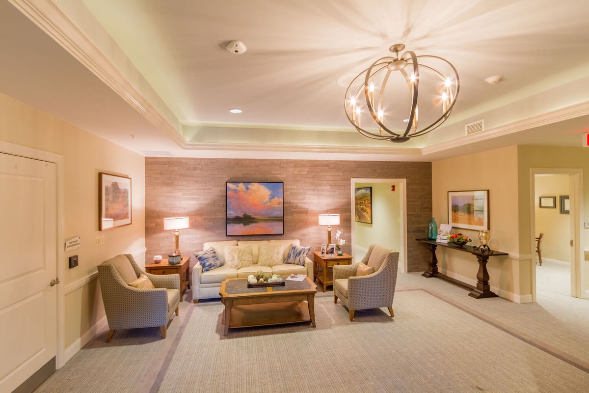 A cozy and elegantly decorated living room with modern furnishings and a stylish chandelier.