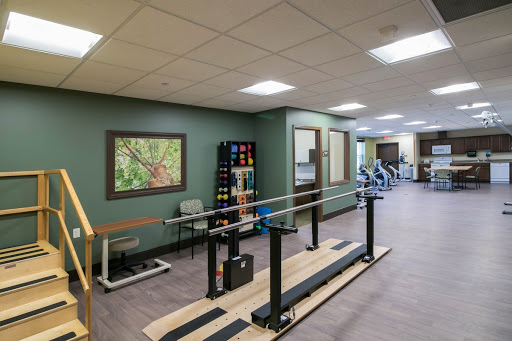 A well-equipped physical therapy gym featuring parallel bars for rehabilitation exercises.