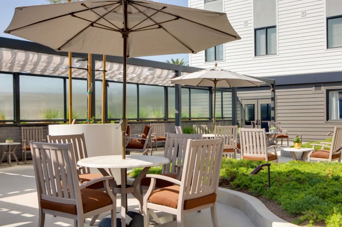 A charming outdoor patio area with tables, chairs, and umbrellas for relaxation.