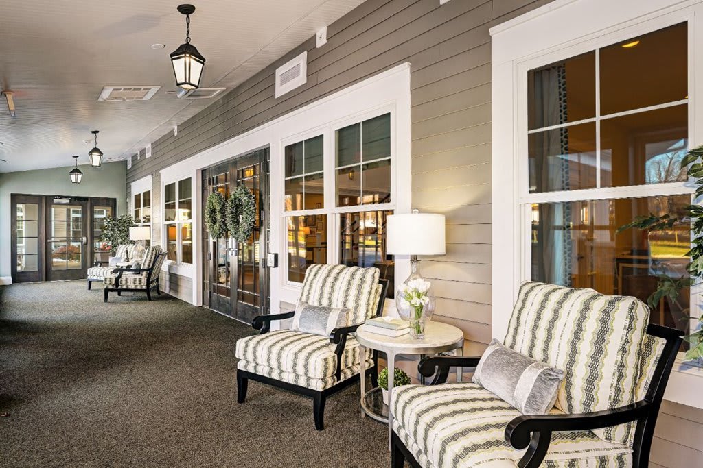 A cozy seating area with striped chairs and decorative elements in a well-lit interior space.
