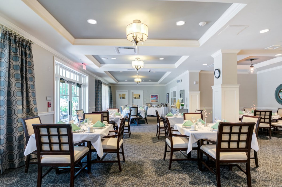 A well-lit dining area with neatly arranged tables and chairs, creating an inviting restaurant atmosphere.