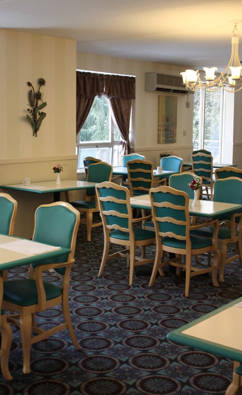 A cozy dining room with neatly arranged tables and chairs, featuring elegant decor.