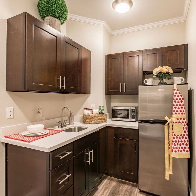 Cozy modern kitchen with dark cabinets and stainless steel appliances.