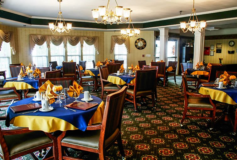 Elegant dining room with well-arranged tables, chandeliers, and classic decor.
