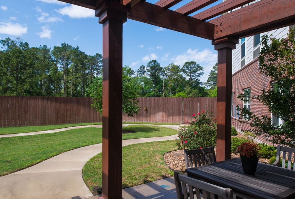 A beautifully landscaped backyard with a pergola and patio area.