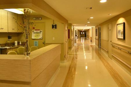 A clean and well-lit hospital hallway with a reception area.