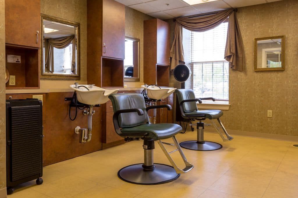 An interior view of a hair salon with chairs, mirrors, and sinks.