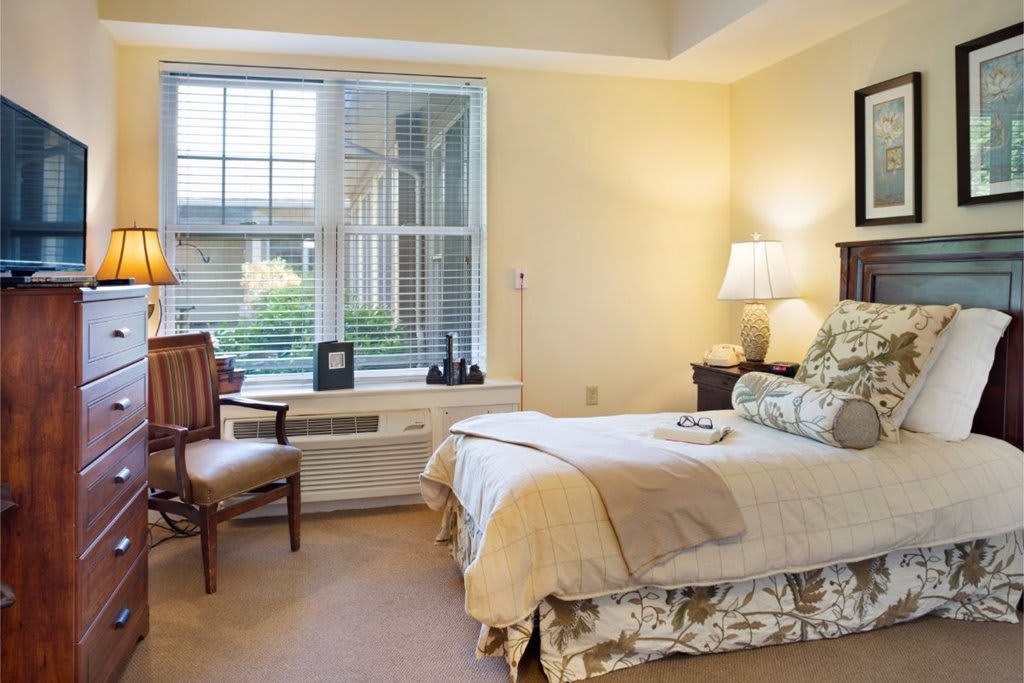 A cozy bedroom with elegant decor and a large window.