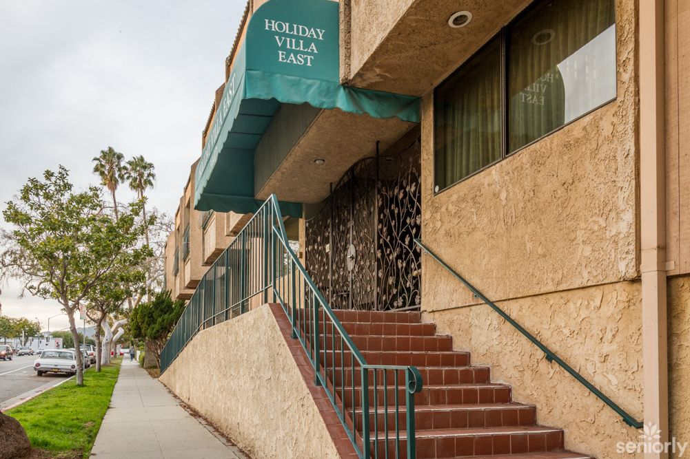 Entrance of a building with an awning and stairs leading up.