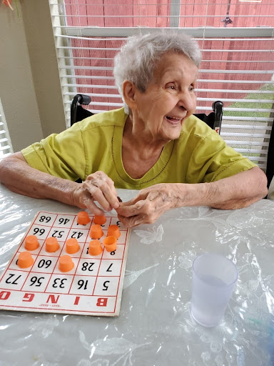 An elderly woman joyfully playing bingo.