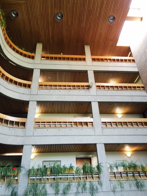 A modern interior view of a building with multiple levels and wooden accents.