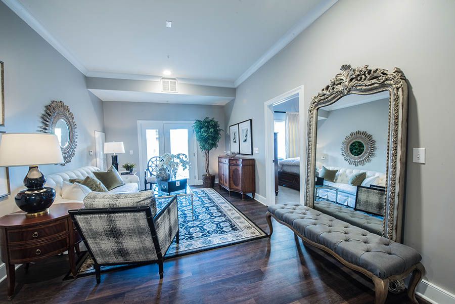 A stylish living room with elegant furniture and a large decorative mirror.