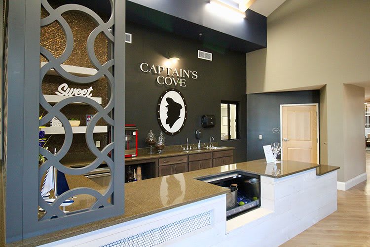 A modern office reception area with a desk and wall signage.