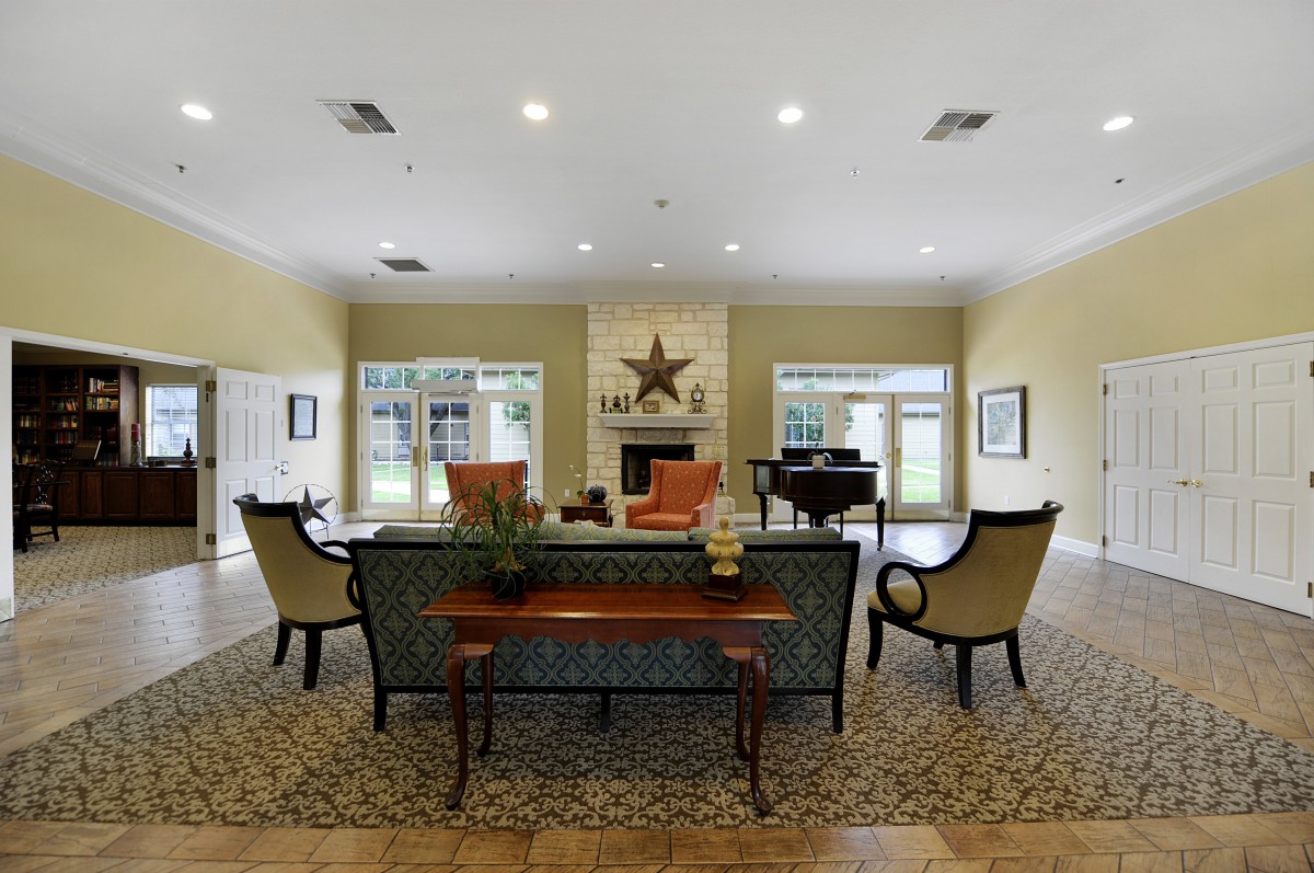 A spacious and elegantly decorated living room featuring a central fireplace.