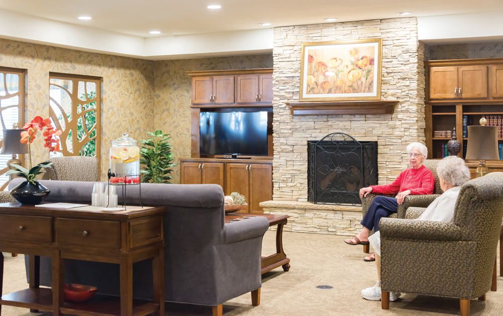 A cozy living room with a stone fireplace, television, and comfortable seating.
