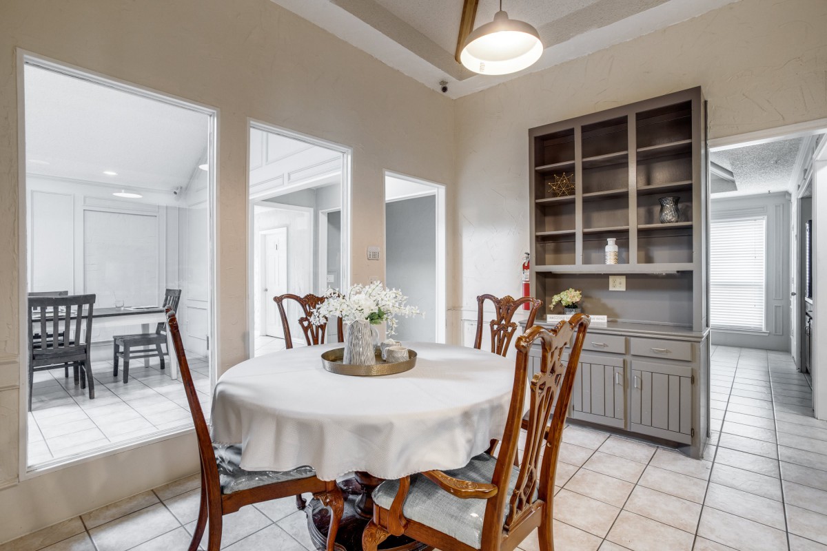 A cozy dining room with a round table set for four and cabinets in the background.