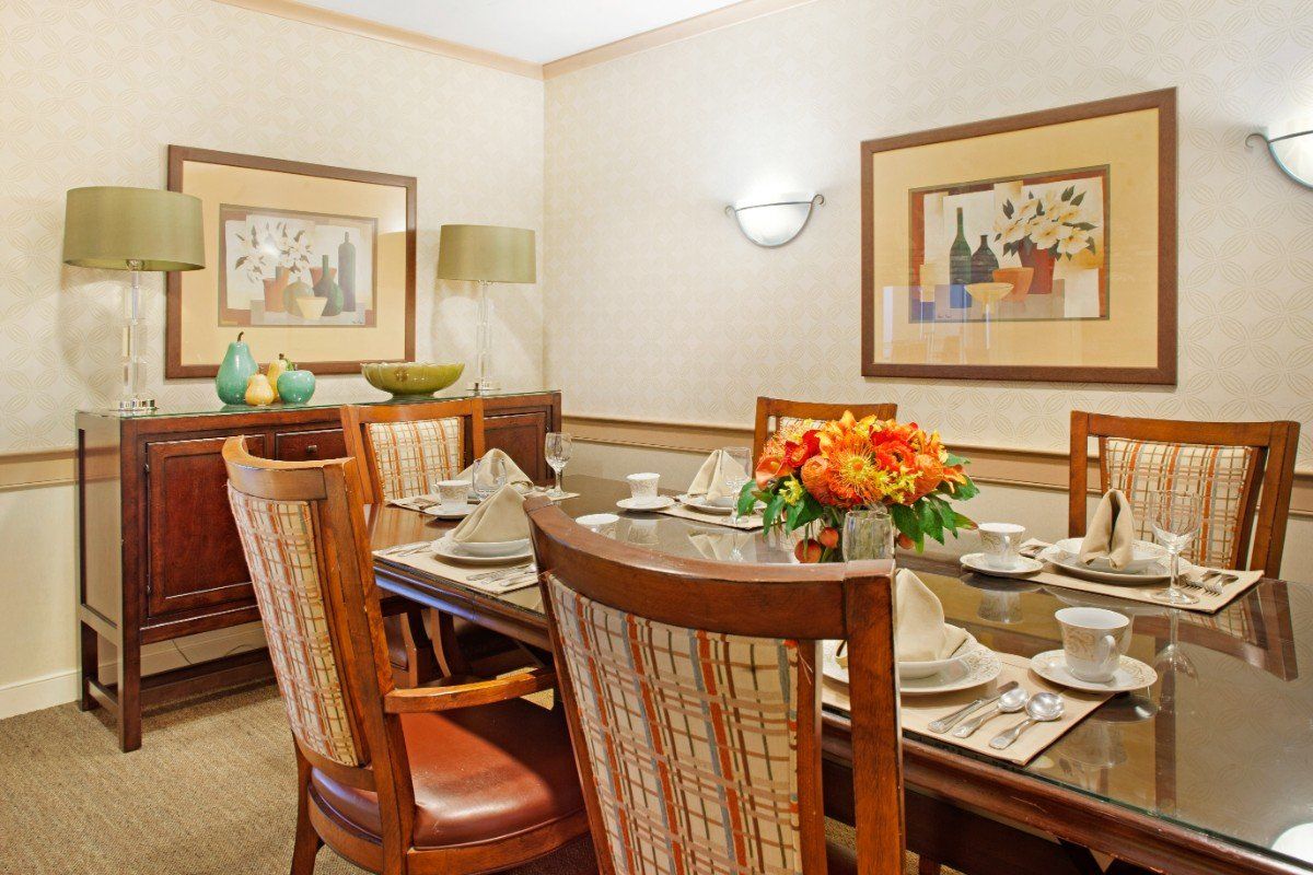 A well-decorated dining room with a set table and floral centerpiece.