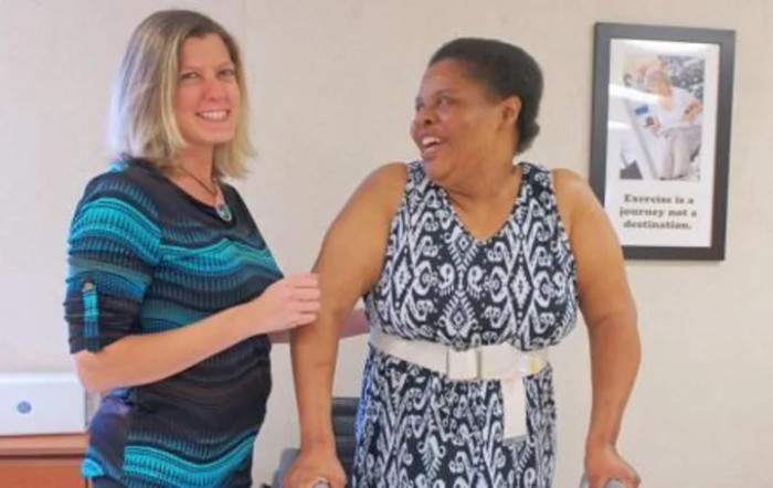 Two women smiling and interacting indoors.
