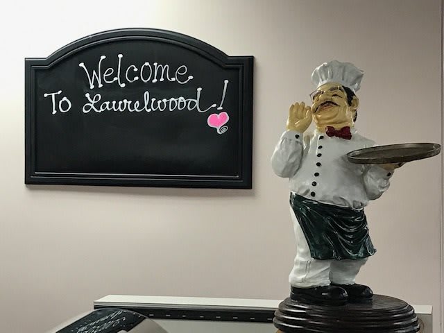 A welcoming display featuring a chef statue next to a chalkboard sign.