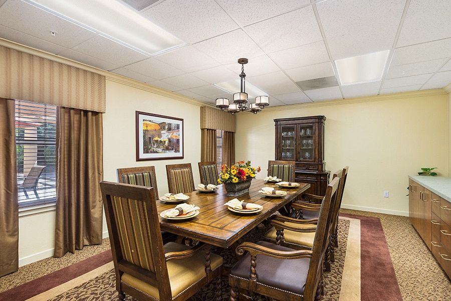 A well-decorated dining room with a large wooden table, chairs, and a chandelier.