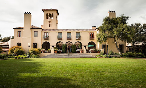 A picturesque mansion surrounded by lush green lawns and elegantly designed gardens.