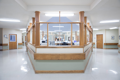 A modern hospital reception area featuring wooden accents and a clean, spacious layout.