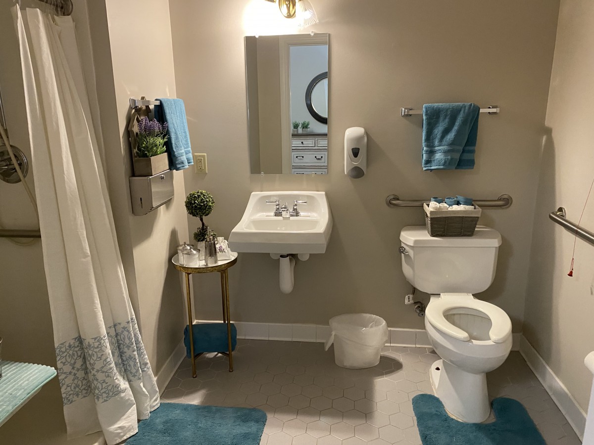 A well-organized bathroom with a sink, toilet, and blue accents.